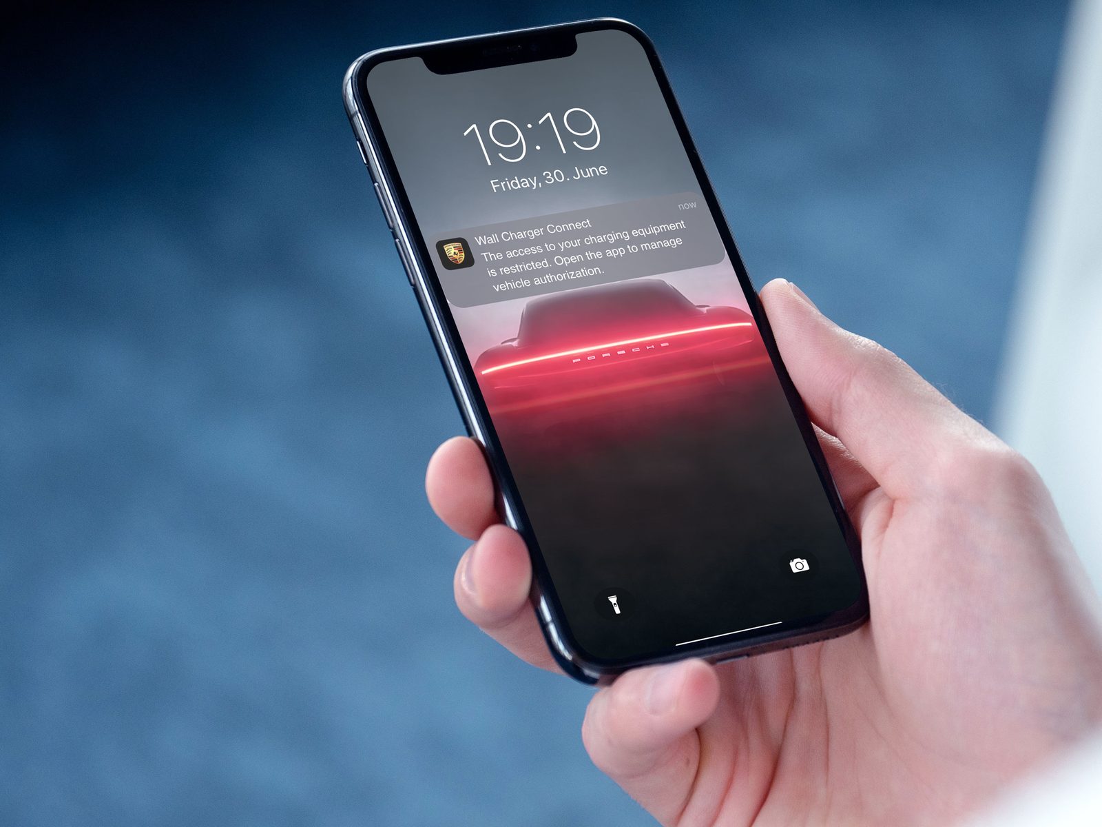 Porsche Connect lock screen notification shown on a phone held in hand